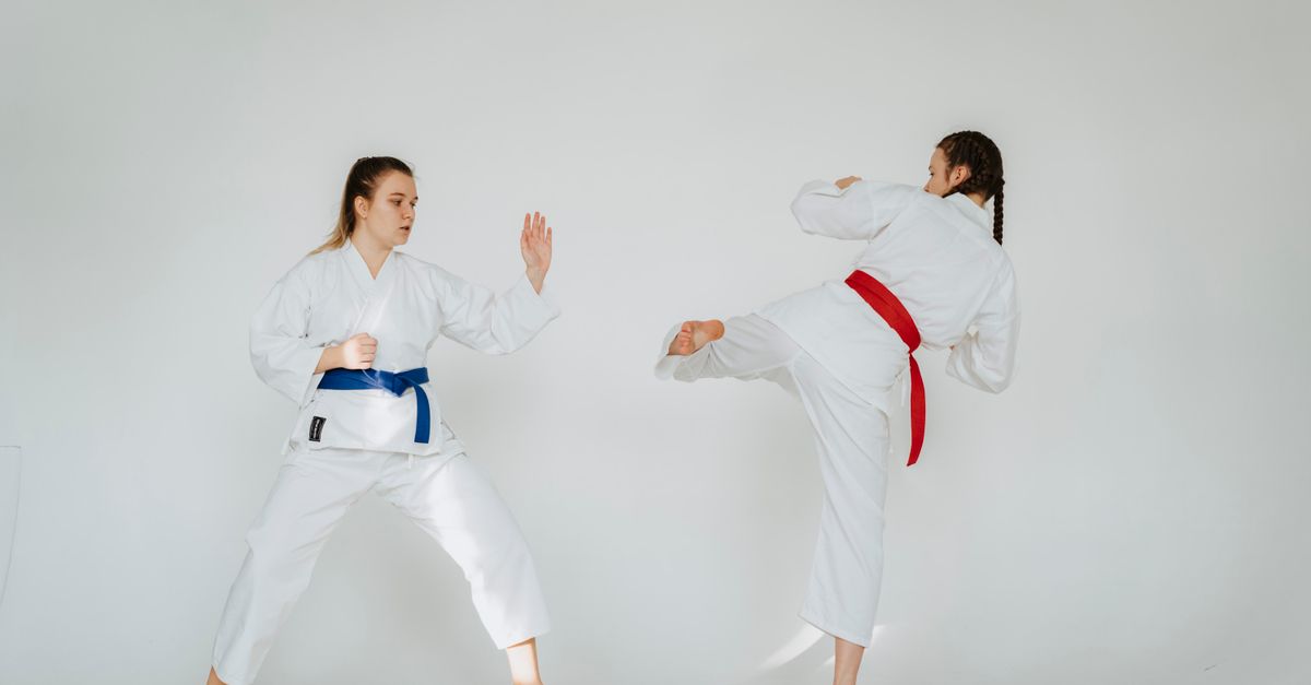 Karate sparring practice with two young women showcasing skill and technique in traditional attire.